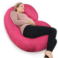Woman lying on a pink C-shaped body pillow on a white background